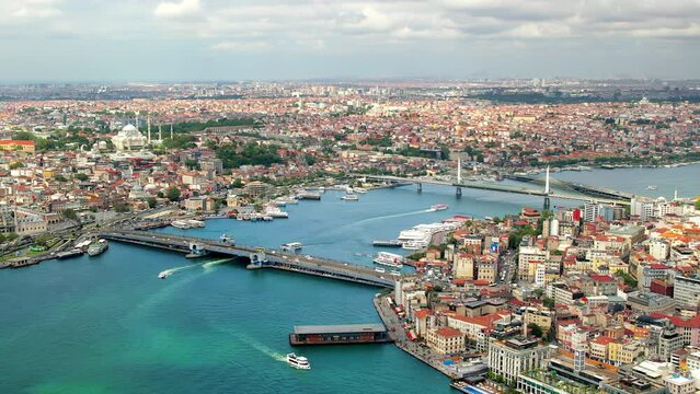 Aerial drone view of Istanbul, Turkey. Multiple residential buildings, mosques, Galata and Metro bridges over the Golden Horn waterway with multiple floating ships