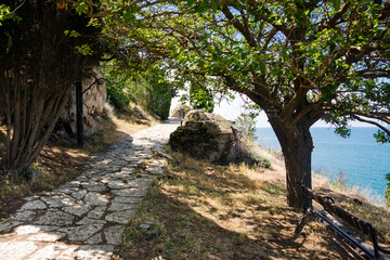 Bulgaria. Stone trail nearby cliffs and medieval fortress ruins in Cape Kaliakra on a sunny summer day with the sea and blue sky in the background.