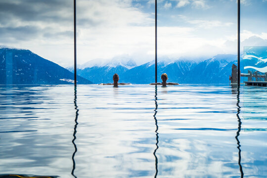Women enjoying the panoramic view from the pool in the alps