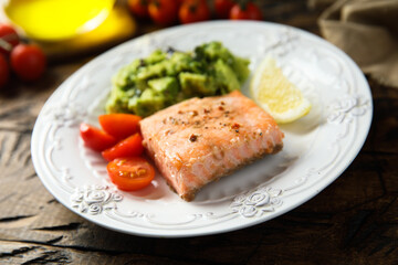 Healthy baked salmon fillet with mashed avocado