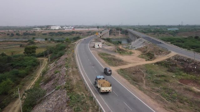 Highway and road bridges built over river basin in the rural terrain, Aerial view, Slow motion
