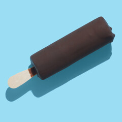 chocolate popsicle with ice cream and hard shadow on blue background, creative decoration of summer concept