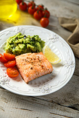 Healthy baked salmon fillet with mashed avocado