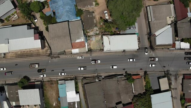 island village of Mae Nam with road traffic and houses - birds view angle - Koh Samu island in Thailand - take from drone - drone moves with traffic