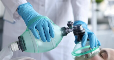 Doctor providing emergency care to patient using ambu bag closeup 4k movie slow motion. Cardiopulmonary resuscitation concept