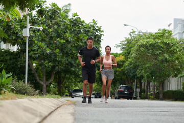 Fototapeta na wymiar Fit young couple jogging in street in the morning