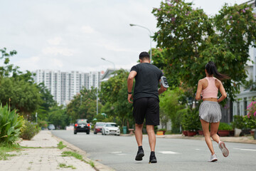 Fototapeta na wymiar Fit young couple jogging in the morning training for marathon