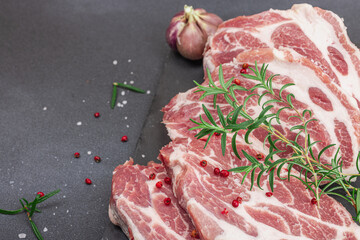 Raw pork neck meat. Chop steak, red peppercorn, garlic cloves, sea salt and fresh rosemary