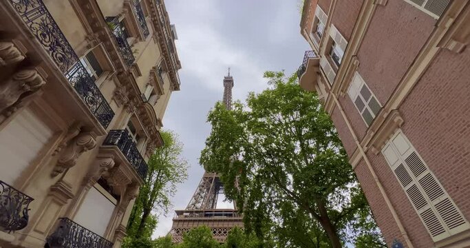 The most popular street and photo spot with the Eiffel Tower in the background. Romantic cozy view of the famous Eiffel tower from a small Paris street in summer. Wide horizontal panorama