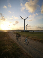 Wind power plants at the western end of the island Kegnaes. Warm evening light, two bikes in the foreground