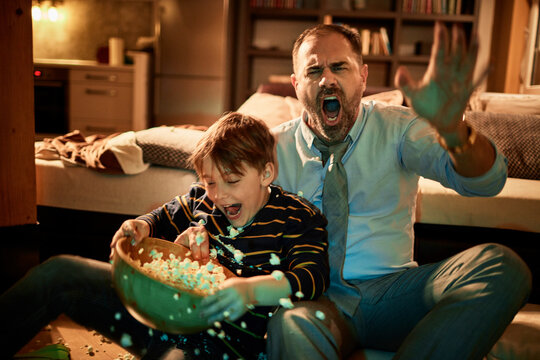 Single Father Watching Football With His Son In The Living Room