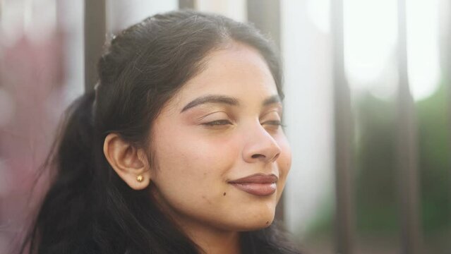 Close up portrait of smiling carefree indian woman feeling absolutely happy and satisfied enjoying great day at city street Self confidence female open eyes and looking ahead feel proud outdoors