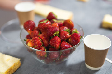  fresh strawberries in a transparent glass bowl on the confectioner's table