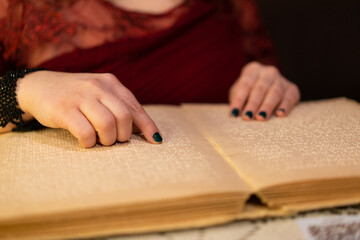 close-up of a woman's hand reading a braille book