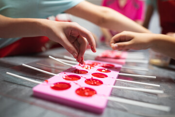 process of making delicious lollipops by pouring them into molds