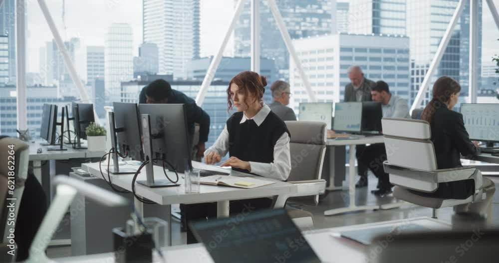 Poster Young Female Data Scientist Typing On Desktop Computer In Bright And Diverse Corporate Office With Megapolis Window View. Professional Caucasian Woman Working In Tech Startup Company With Colleagues.