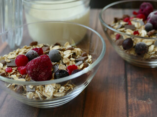 Zwei Schalen mit Müsli, Obst und Milch