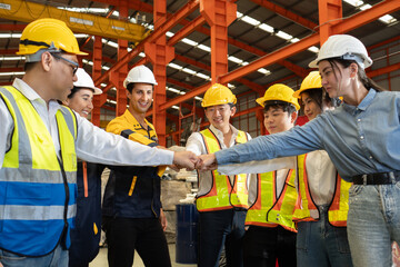 Group of diverse workers standing together in storehouse holding hands. Multicultural team working in logistic distribution warehouse Latino, Caucasian and Asian people in manufacturing industrial.