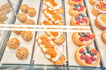 fresh pastries with berries. A variety of fresh pastries in the bakery window. almond croissant is fresh and hot in a cafe next to other types of pastries. The interior of an Italian restaurant.