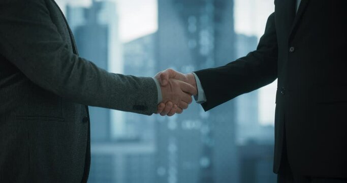 Close Up on Business Partners Sahking Hands After Agreeing On Profitable Deal in Office Meeting Room. Corporate CEO and Investment Manager Handshake in Slow Motion. Dramatic Evening Edit.