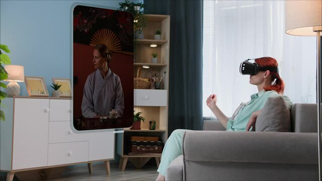 modern technology,  young woman in VR glasses looks at photos from a smartphone gallery while sitting on a sofa in a room