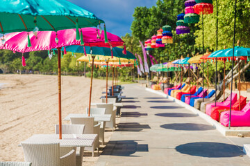 Cafe with colorful balinese umbrellas at beach in Bali, Nusa Dua. Beach club restaurant