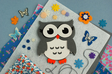 Felt craft in the form of an owl on a gray background. Various crafts from felt. Felt for...