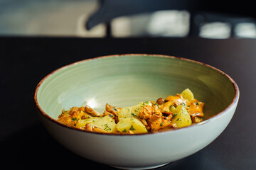 Fresh summer lunch made with vegetarian local produce. Wild chanterelle mushrooms with boiled potatoes and herbs in a bowl on the table
