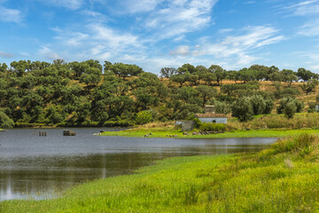 Traditional Alentejo landscape in Portugal with a little abandoned house in the margins of a little water dam