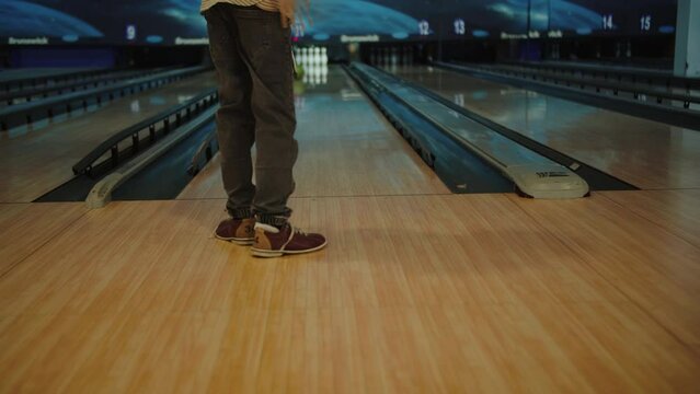 Boy plays bowling, the child throws a bowling ball.