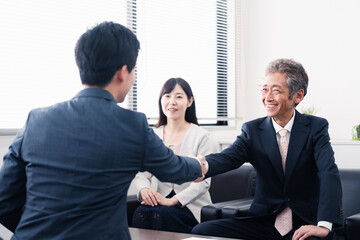 契約が成立し握手をするビジネスパーソン