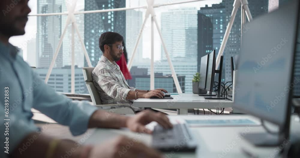 Poster portrait of a young indian business account manager working on a desktop computer in a modern corpor