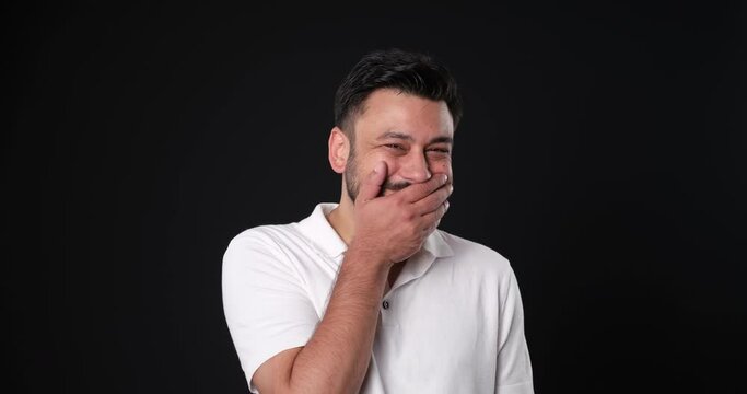 The when a middle-aged man in a studio setting, through close-up shots, looks at the camera and makes facial expressions that show his excitement after receiving a compliment
