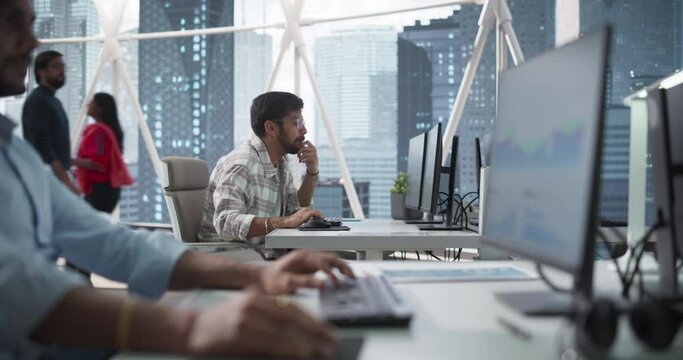 Team of Talented Young Indian Professionals Working in a Corporate Banking Agency. Financial Analysts and Managers Working on Computers in a South Asian Business Office with City View with Skyscrapers
