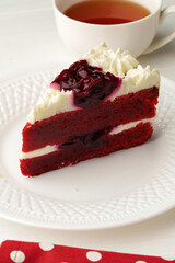 Piece of red velvet cake on white table