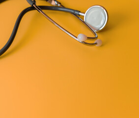 Fototapeta na wymiar Medical gray statoscope on a yellow background.