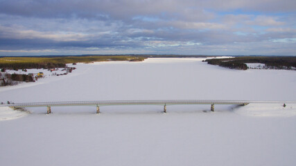 Aerial view of frozen lake and bridge at winter
