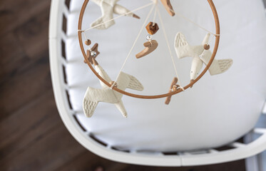 Kids handmade toys above the newborn crib.