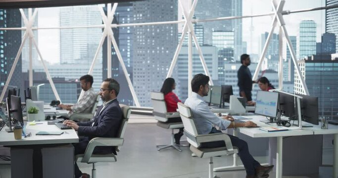 Team of Talented Young Indian Professionals Working in a Corporate Hedge Fund. Financial Analysts and Managers Working on Computers in a South Asian Business Office with Scenic City View