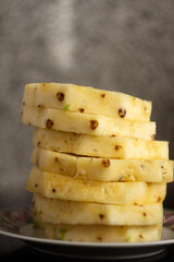 pineapple slices stacked on top of each other on a plate on a blurred background