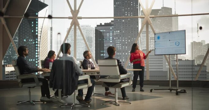 Diverse Indian Office Conference Room: Young South Asian Female CEO Makes a Presentation for Entrepreneurs, Talking, Using TV with Infographics and Statistics. Businesspeople Discussing Reports