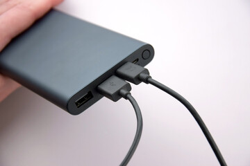 Power bank for charging mobile devices. Black smart phone charger with power bank.