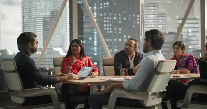 Finance Department Having a Meeting to Discuss a Project with a Team Leader. South Asian Colleague Using Laptop Computer, Working in Modern Office, Employees Having a Conversation in a Conference Room