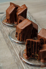 Chocolate sponge cake coated with chocolate sauce on glass plate