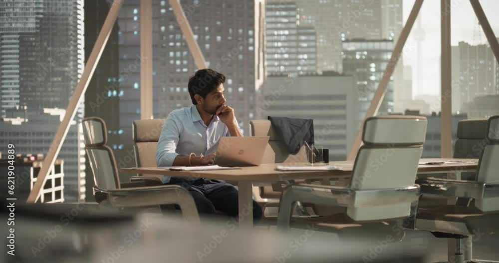 Poster indian executive manager working in a business research and development office on a laptop computer.
