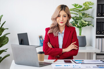 Portrait of a woman business owner showing a happy smiling face as he has successfully invested in her business using tablets and financial budget documents at work.