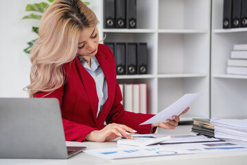 Consultant, Asian businesswoman working on the phone who discussion financial work and marketing business plan to increase company profits, ready to use computer and marketing planning documents.