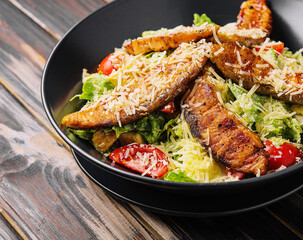 Caesar Salad with Salmon on wooden table