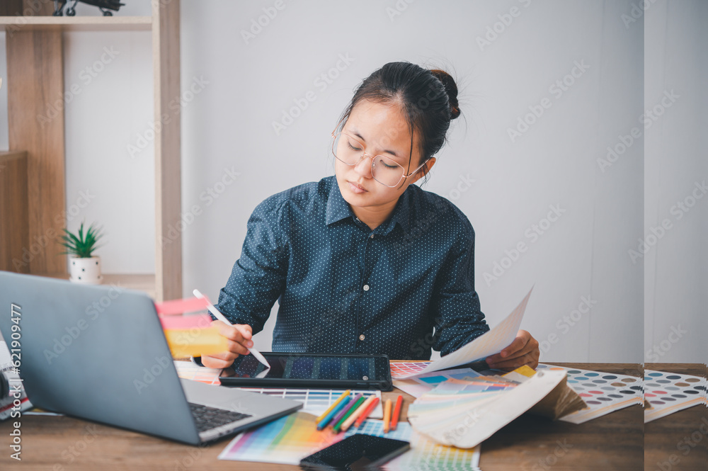 Fototapete Graphic designer architects who work with laptops and color comparison tables for design work..