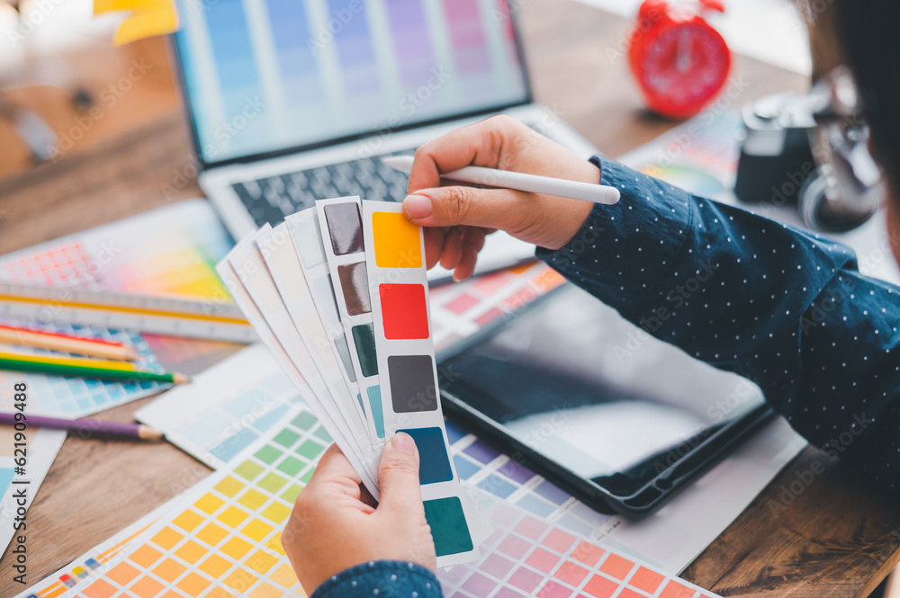 Poster graphic designer architects who work with laptops and color comparison tables for design work..